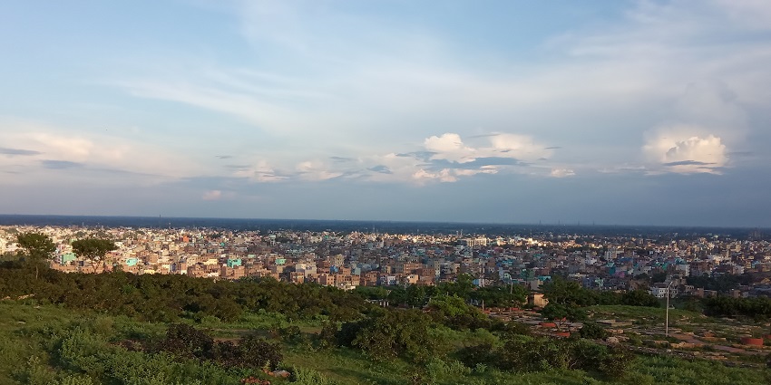 Bihar Sharif city from above a green hill, and the city covered in buildings and structures