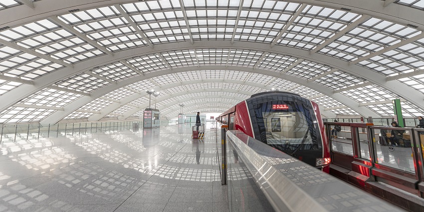 An image of Beijing Capital International Airport in Asia, showcasing a modern terminal with passengers