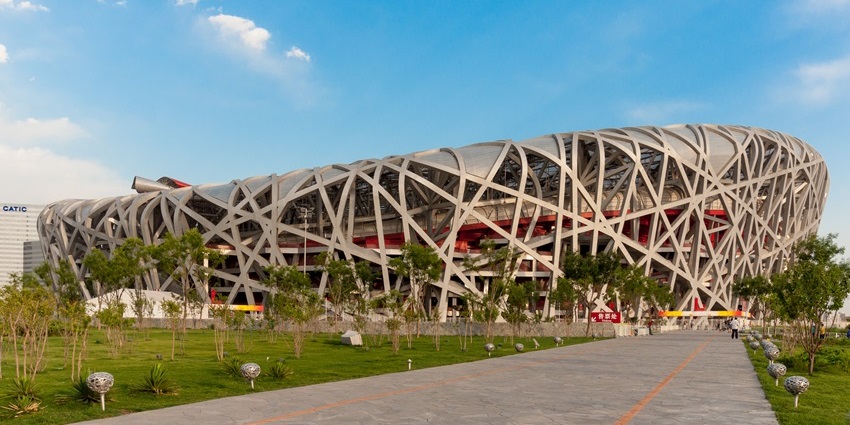 The Beijing National Stadium is standing under a clear sky, showcasing its steel design.