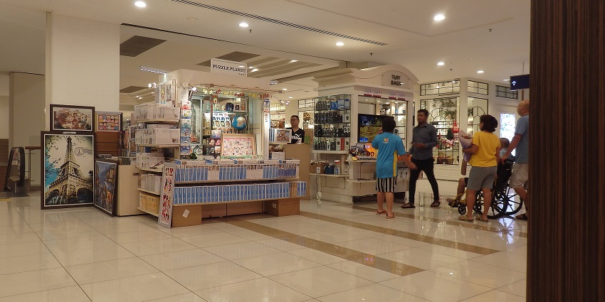 Visitors enjoying shopping at a souvenir shop in Gurney Plaza selling painted frames.