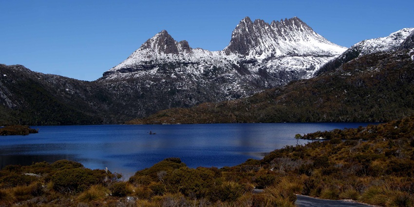 A picture of Cradle Mountain with snow-capped peaks during winter.