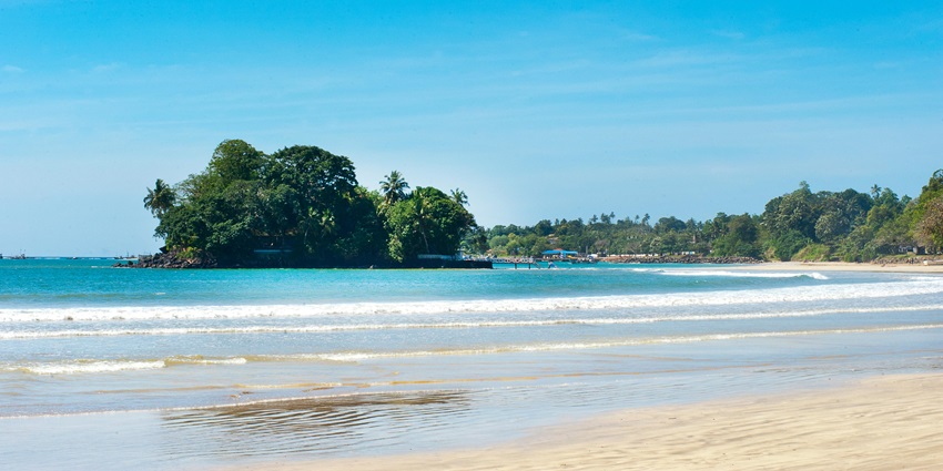 A bright sunny day in Sri Jayawardenepura Kotte, with clear skies and a water body.