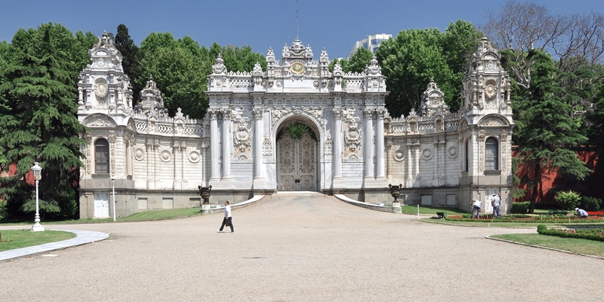 A picture of Dolmabahçe Palace on a sunny day, reflecting in the Bosphorus waters.