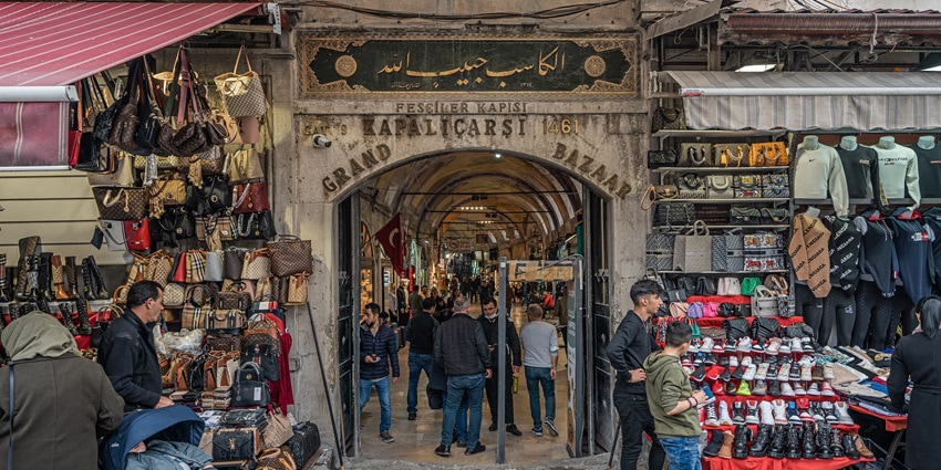 An image of the Turkish Grand Bazaar with colorful shops and crowded people.