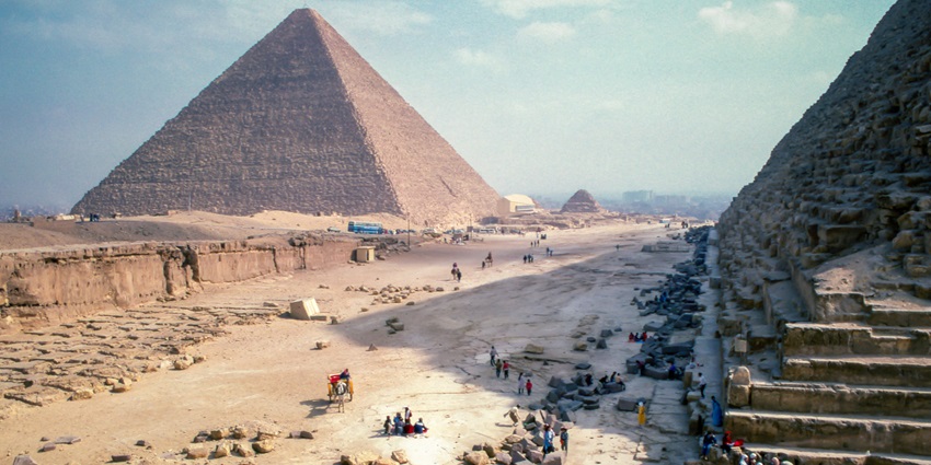 Panorama of Saqqara Necropolis against a blue sky, featuring ancient tombs