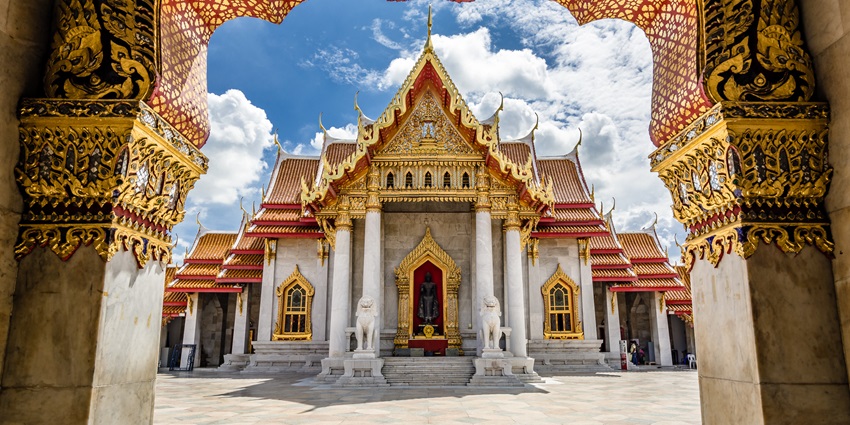 An image of Wat Benchamabophit glowing under the golden light of sunset.