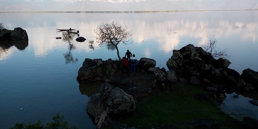An image of the Wular Lake with reflections of snow-capped mountains in the distance