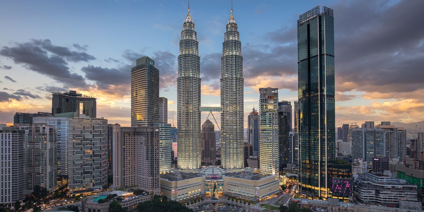 Skyline of Kuala Lumpur featuring the iconic Petronas Towers at sunset in Malaysia