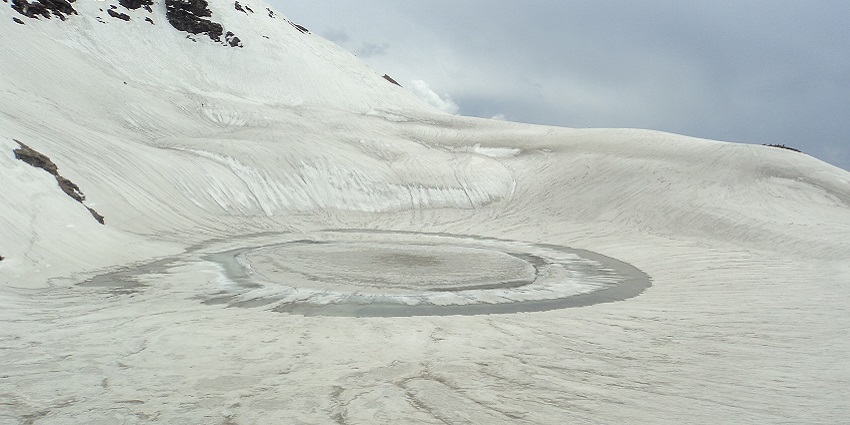 An image of Bhrigu Lake in Kullu, surrounded by high-altitude terrain and rocky slopes.