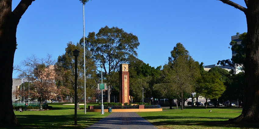 Biggie park with two big trees on both sides and a monumental clock in the middle