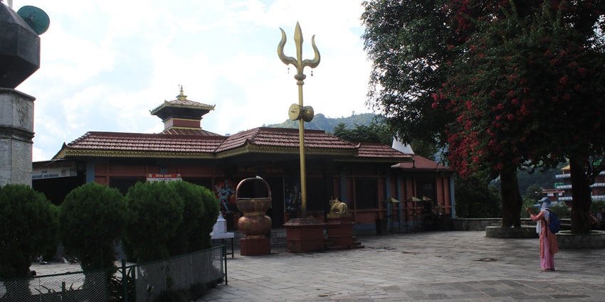Bindhyabasini temple complex with traditional architecture and a woman standing outside