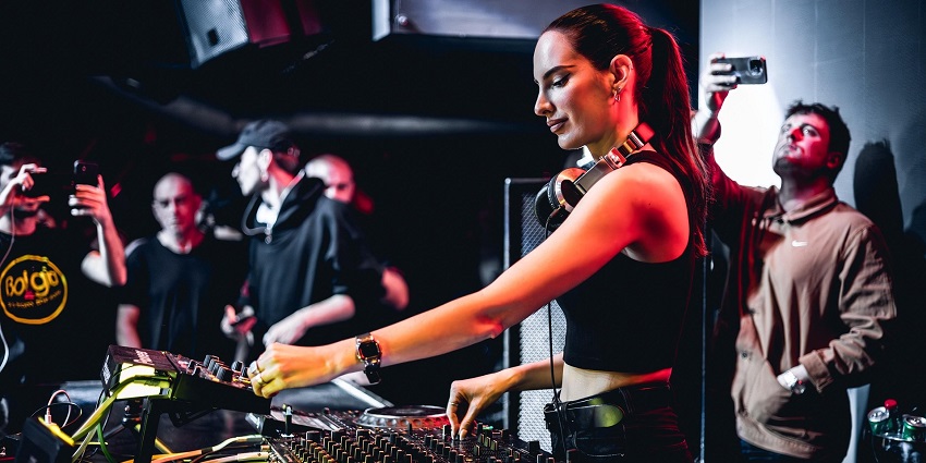 An image showing a music event with a DJ performing at a party similar to Black Moon and Escape.