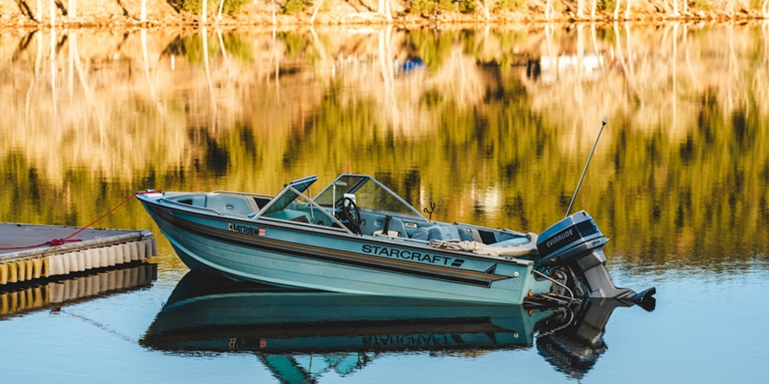 A view of a boat sailing on the glistening blue waters of the water body of Karnataka.