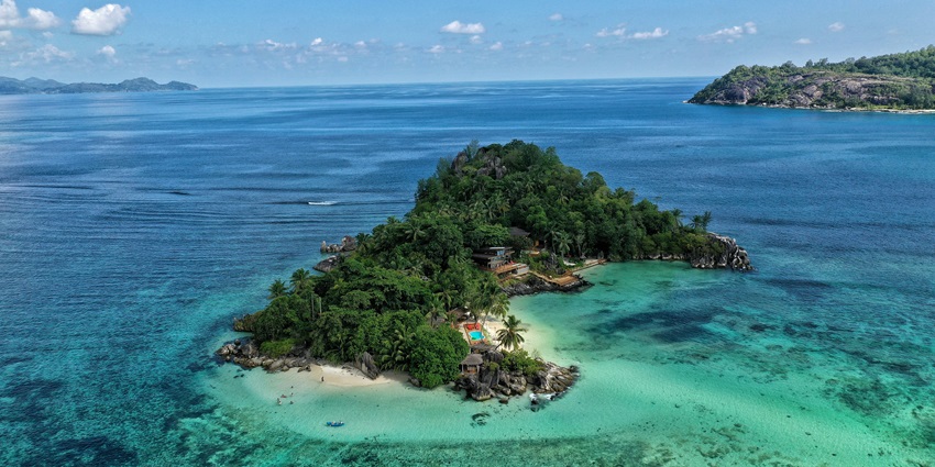 Image of a coastline with a sandy shore of Bomatu Beach, extending towards the horizon.