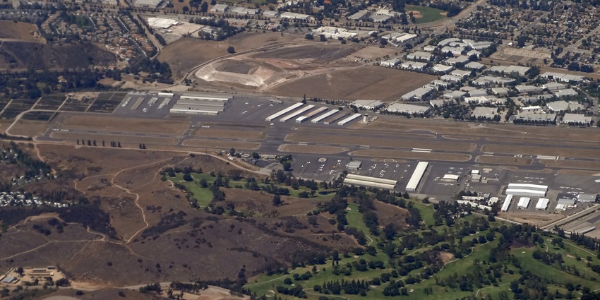 Brackett Field Airport from above with distant airport white buildings and a long runway.