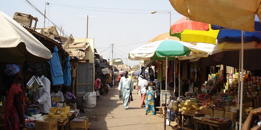 A vibrant Brikama Market in The Gambia, bustling with locals and colourful goods.