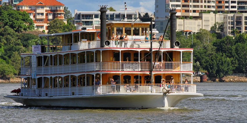 Scenic Brisbane River Cruise with a modern ferry gliding past the city skyline at sunset.