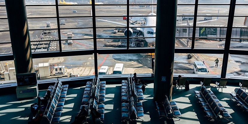 View of the Airport terminal with seating and large windows overlooking the runway.