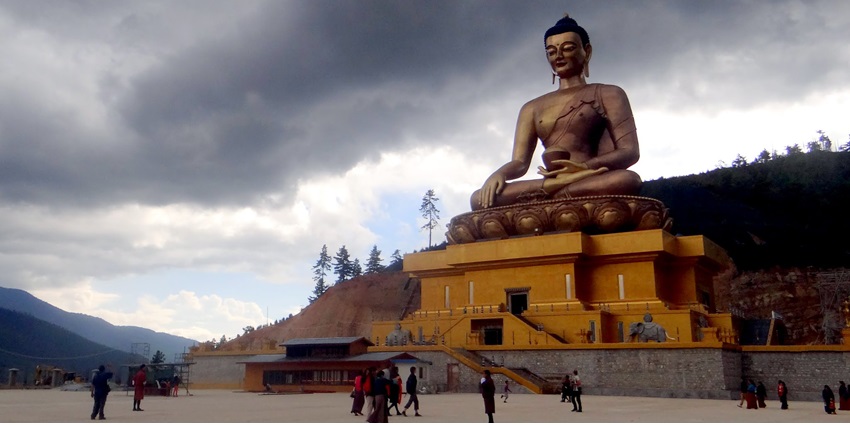 A grand statue of Buddha Dordenma overlooking the Thimphu Valley, surrounded by lush greenery and mountains.