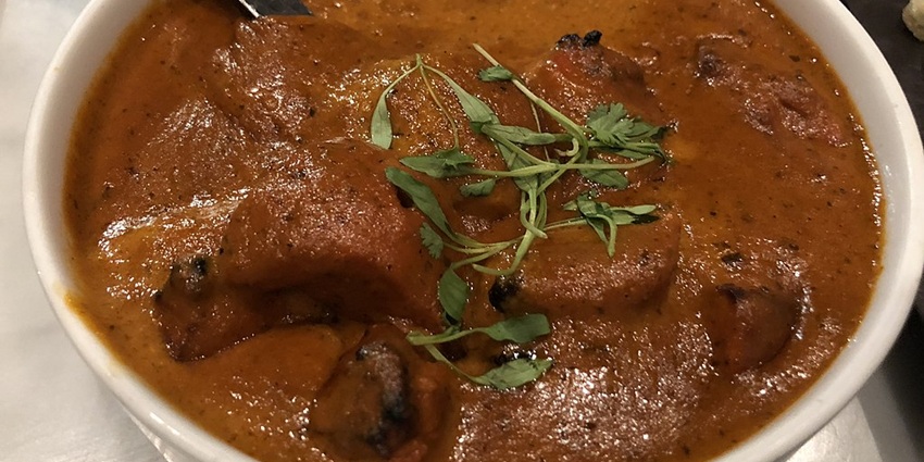 Butter chicken is served with naan, highlighting North India’s culinary heritage
