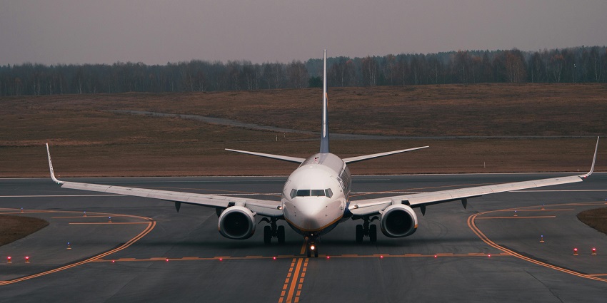 Aeroplane parked on the runway with sunset and sun rays coming through the windows.
