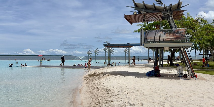The Cairns Esplanade Lagoon with families enjoying the calm waters and views of the coastline.