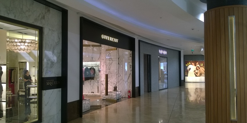 Brightly lit mall interior featuring a Givenchy store with an elegant and modern storefront