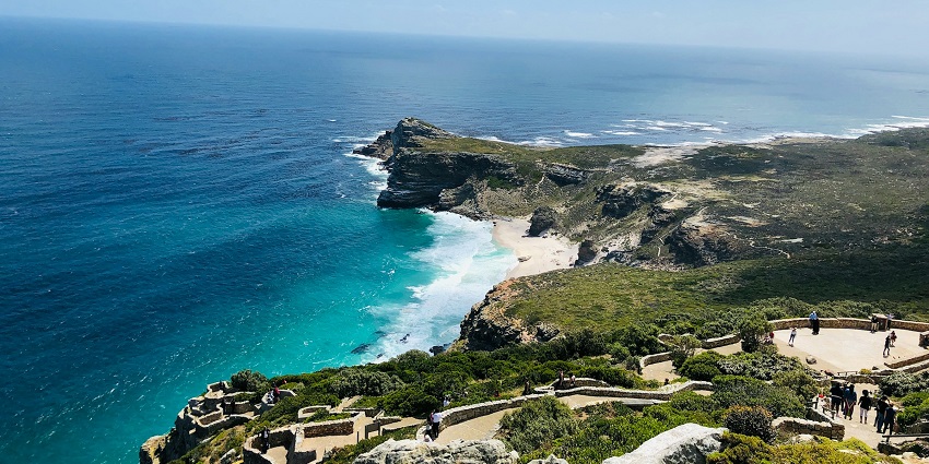 Cape Point lighthouse on a high cliff with blue ocean in the background, a famous destination.