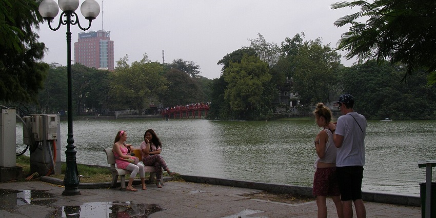 Visitors strolling along the pathway around Hoàn Kiếm Lake.