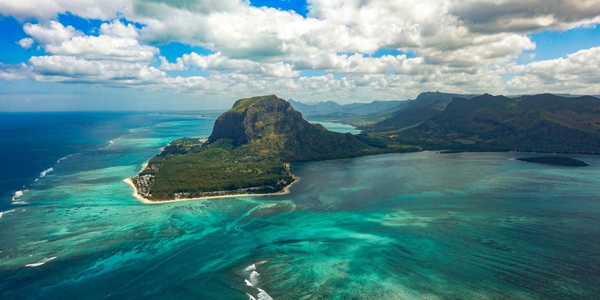 A dark and dramatic landscape of Pont Naturel surrounded by turquoise waters.