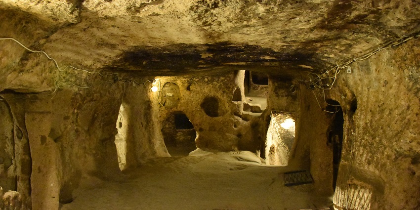 A picture of a visitor taking photos of the rock-cut tunnels inside Kaymakli Underground City.