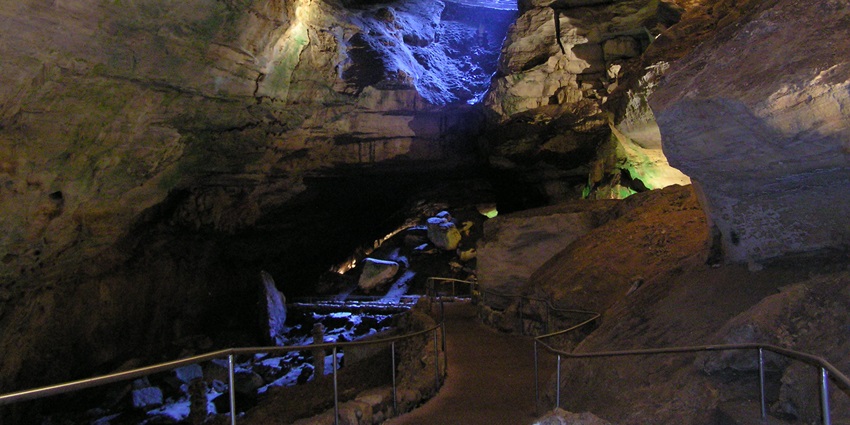 A woman standing in awe inside the majestic Carlsbad Caverns enjoying the serene view.