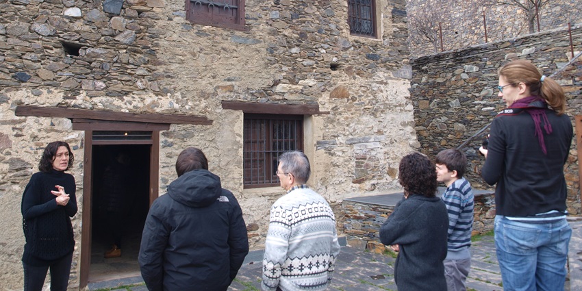 A guide is explaining historical details while visitors are standing and listening.