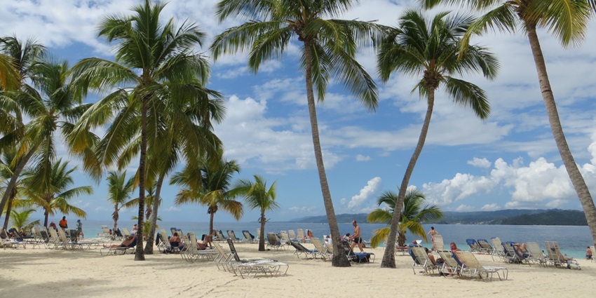 A small, picturesque island with lush greenery and crystal-clear Caribbean waters.
