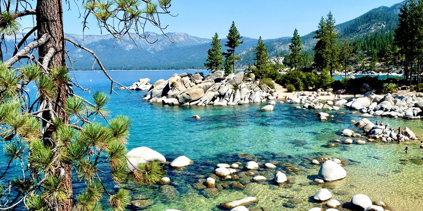 Scenic lake surrounded by forested mountains, one of the lakes in Kangra, India.