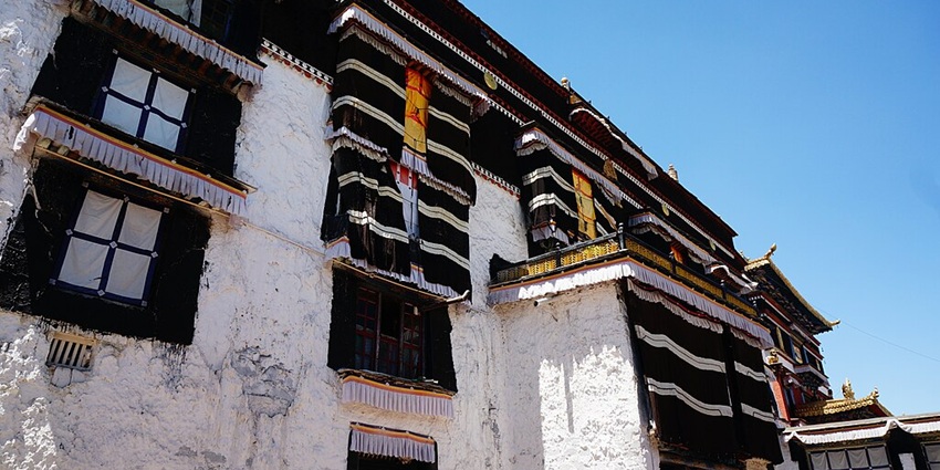 Traditional architecture of a Tibetan monastery and widows covered with black curtains