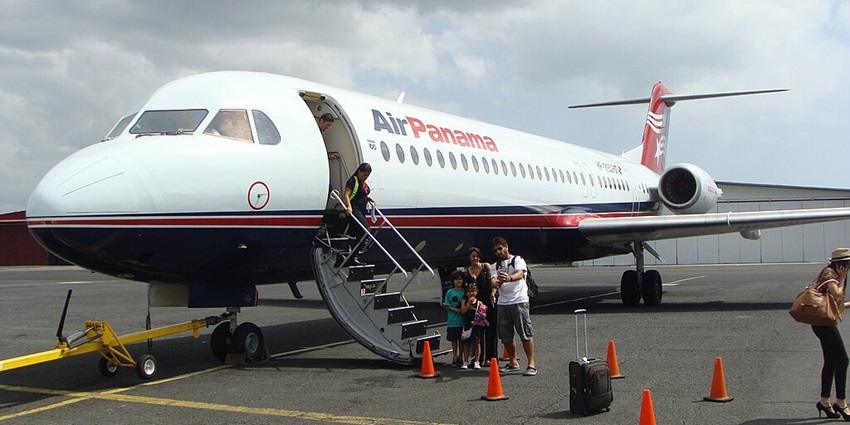 Air Panama Fokker 100 with passengers deboarding as a family poses for a photo near the aircraft