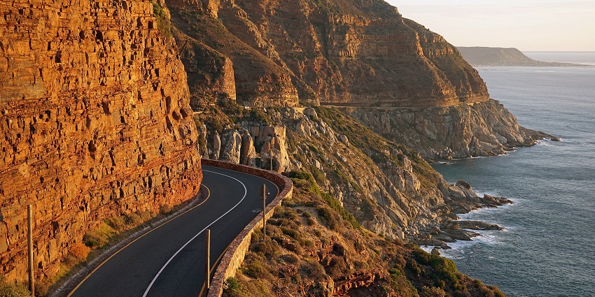A beautiful coastal road with cliffs on one side and the sea on the other, giving ocean views