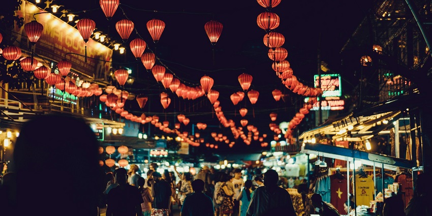 A glimpse of a lively street market with food stalls, clothes, and handmade souvenirs.