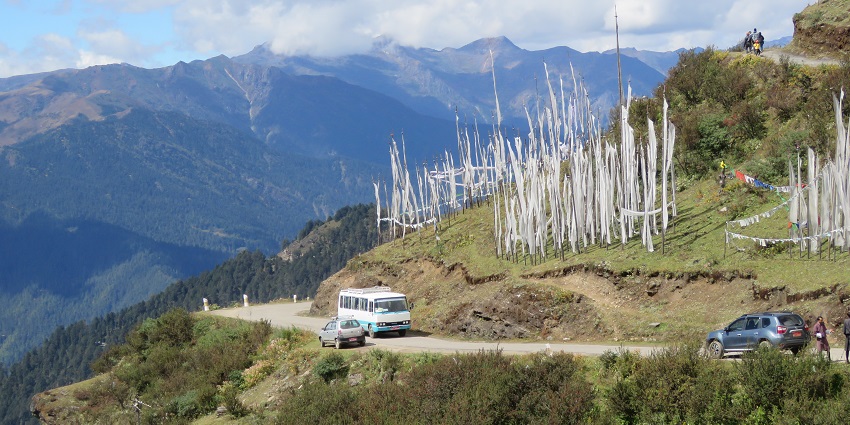Snow-capped mountains seen from Chele La Pass, surrounded by dense forests and breathtaking views.