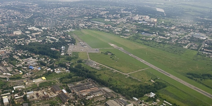 Panoramic aerial view of Chernivtsi International Airport (CWC) with aircraft and city greenery