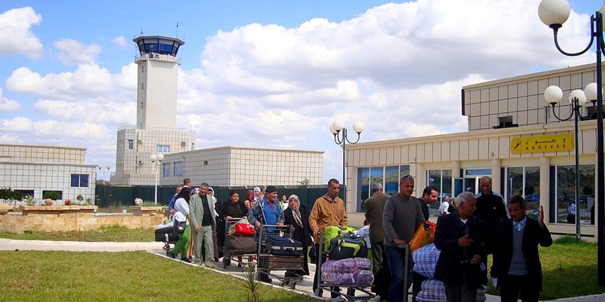 Terminal of the Chlef international airport with passengers pushing their trolleys