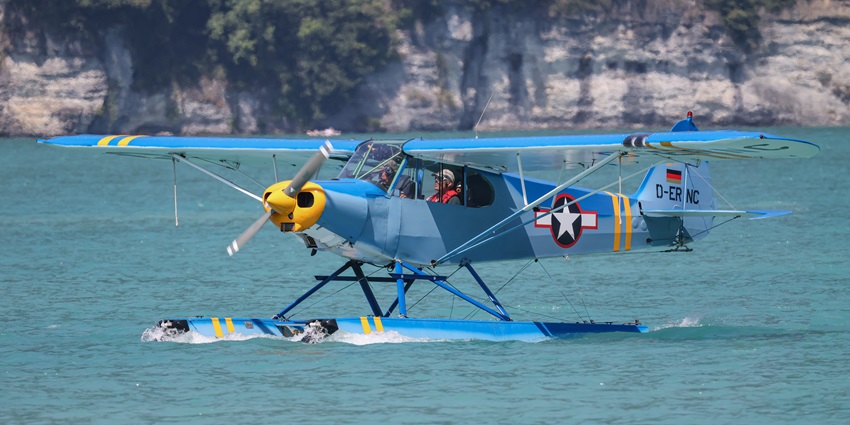 A pilot is gearing up to take off on his single-engine seaplane at a seaplane base.