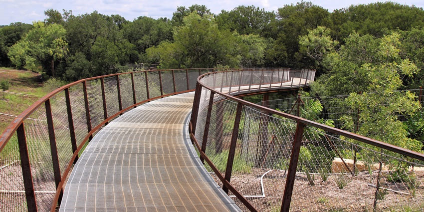 A bridge located amidst lush green trees.
