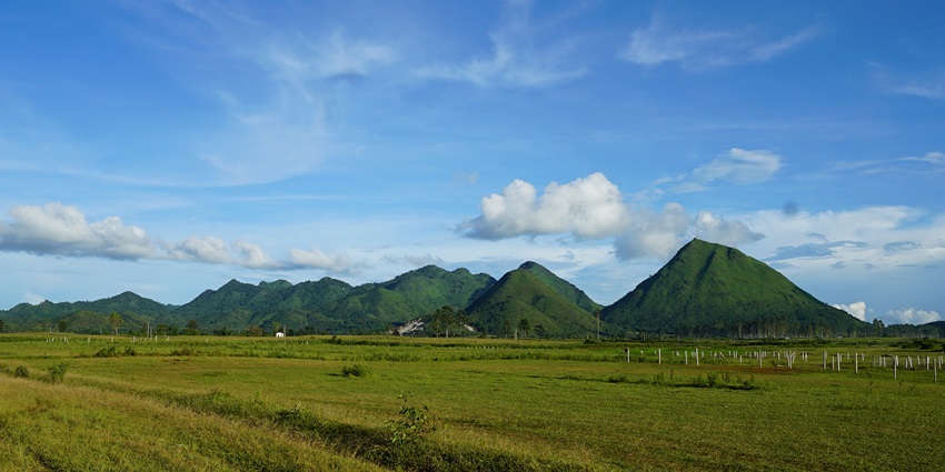 An image showing the sunrise over Sam Mountain in Chau Doc, Vietnam, with a clear sky view.