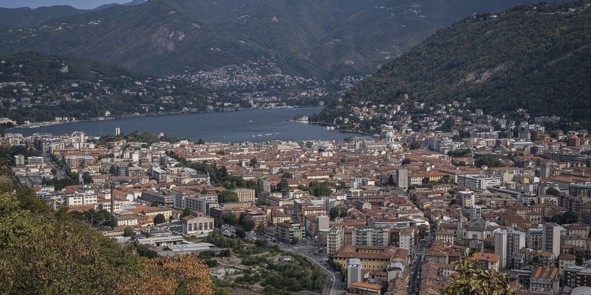 The panoramic view of Como, with its historic buildings, lakefront, and mountains.