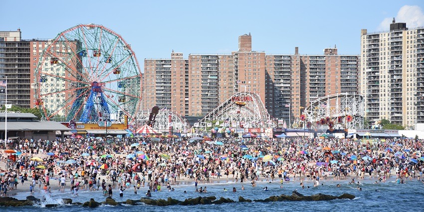 An image of Coney Island’s boardwalk with bright lights and amusement rides on New Year’s Eve in New York.