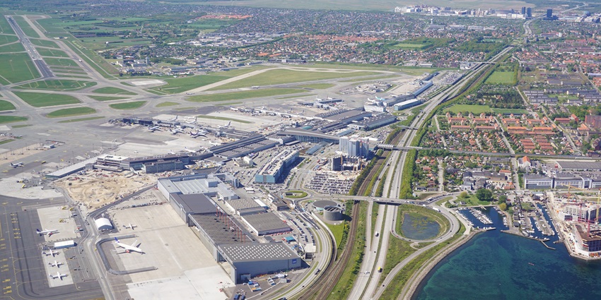 Aerial view of Copenhagen Airport with runways, terminals, and surrounding landscape.