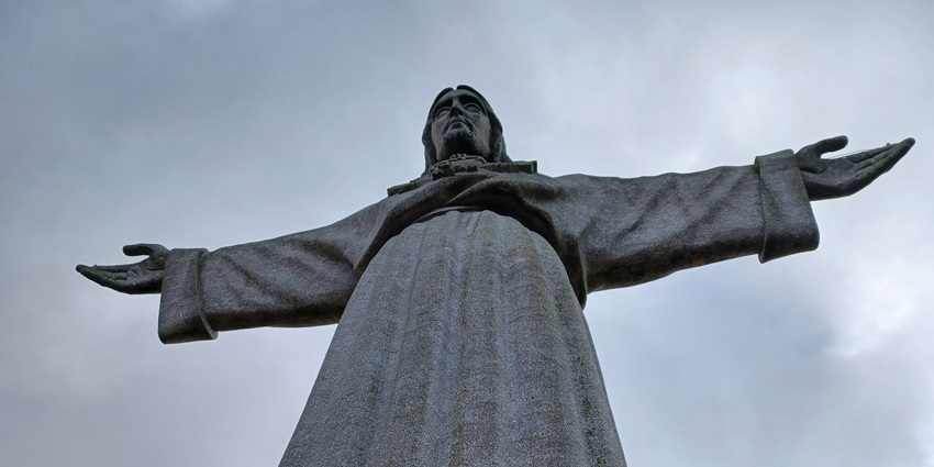 An image of a towering statue of Christ offering panoramic coastal views over Dili.