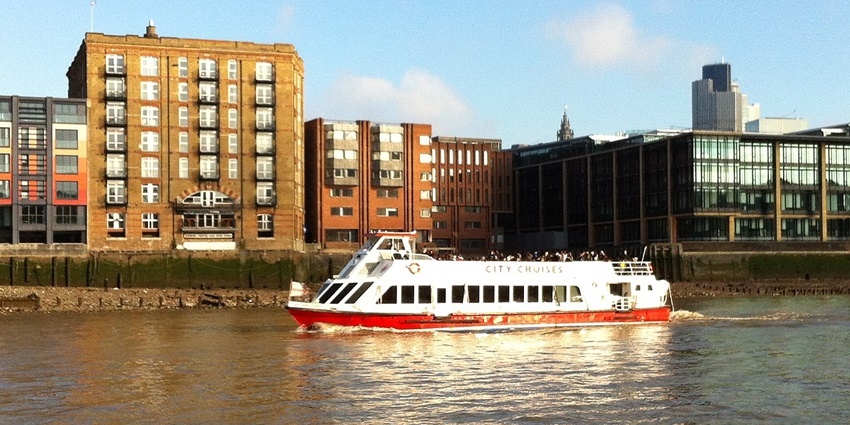Passenger boat M.V. Thomas Doggett cruising on the River Thames in London, UK.